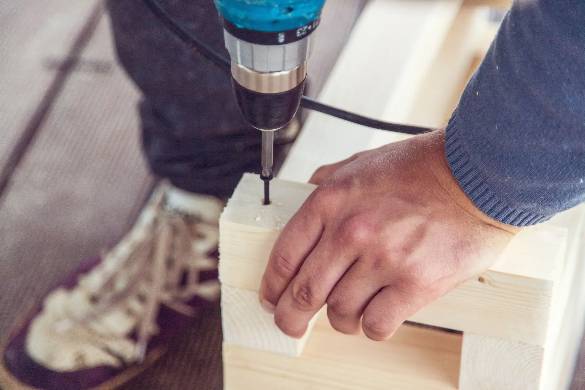 Close-up of a craftsman fastening two pieces of timber
