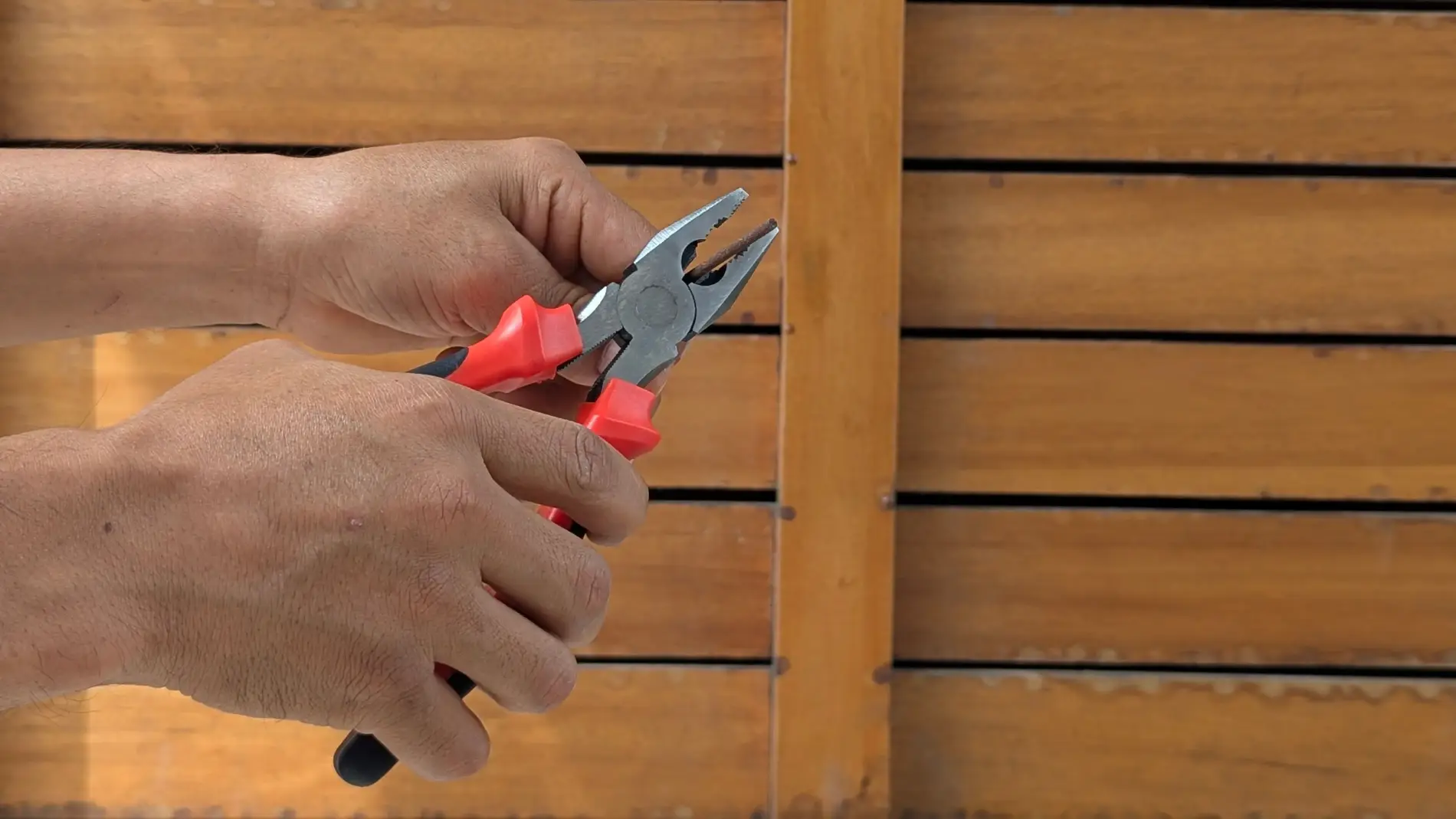 Hands using pliers during a small home repair
