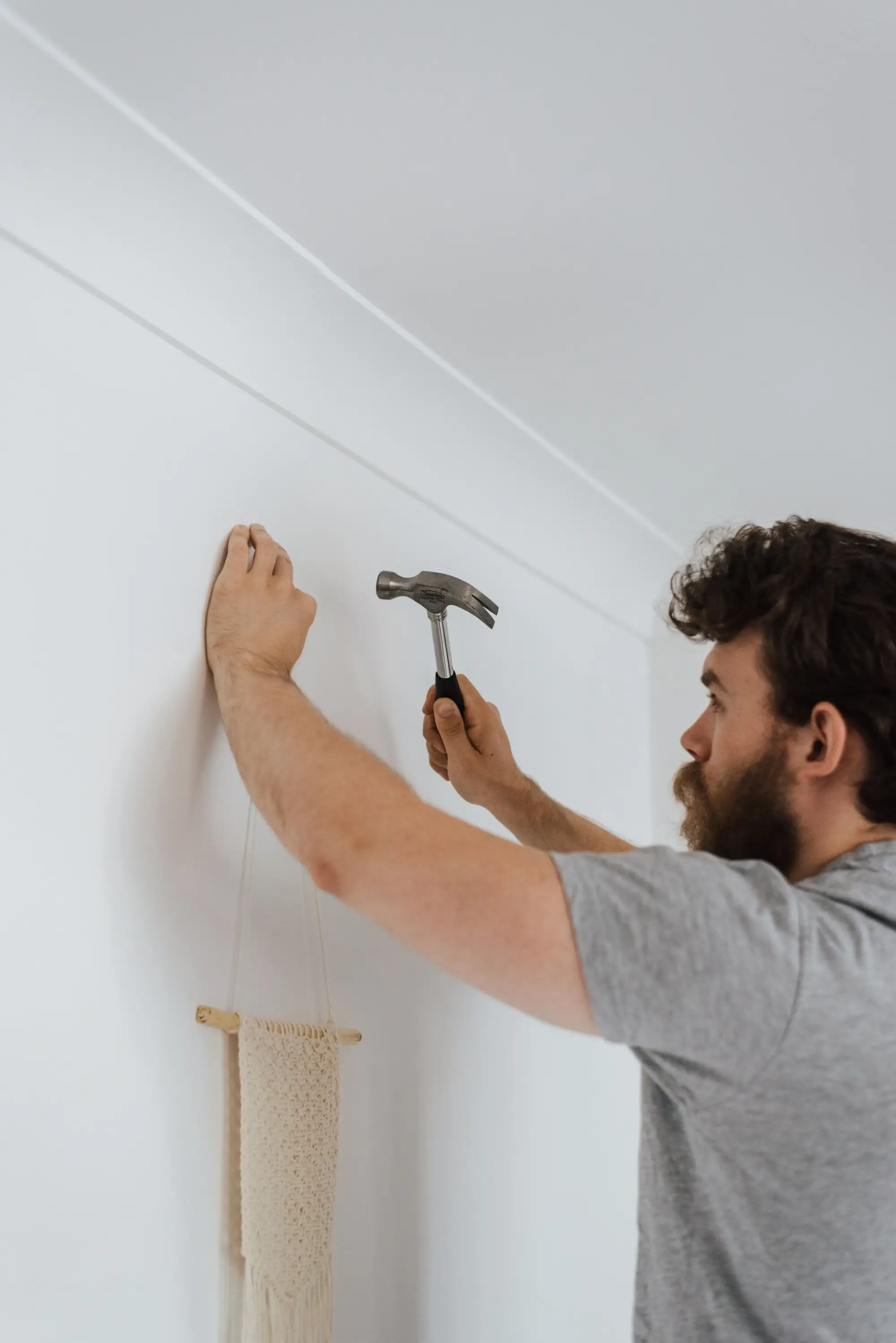 Handyman carefully hanging a frame in a customer’s home