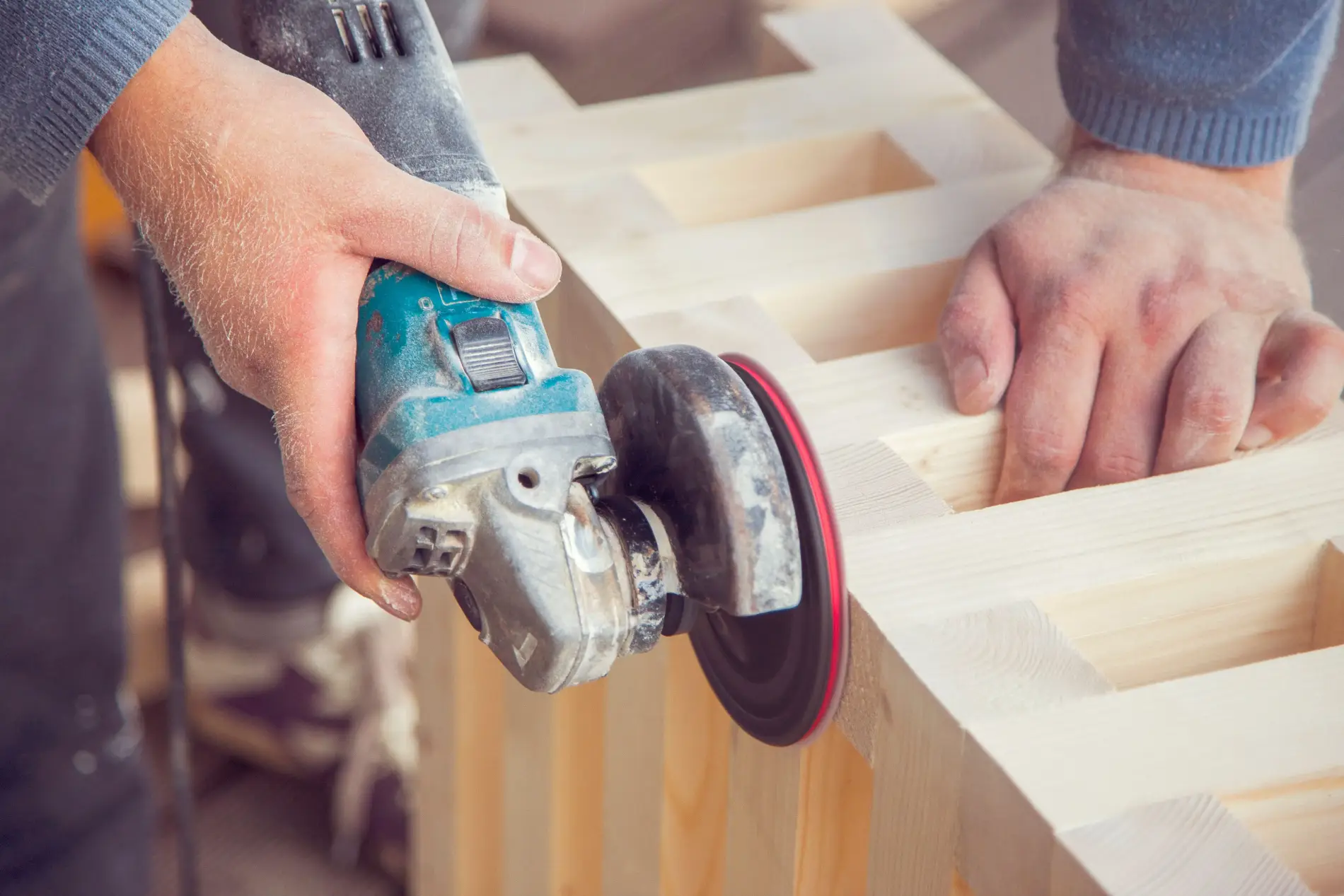 Craftsman smoothing a timber frame with a power tool
